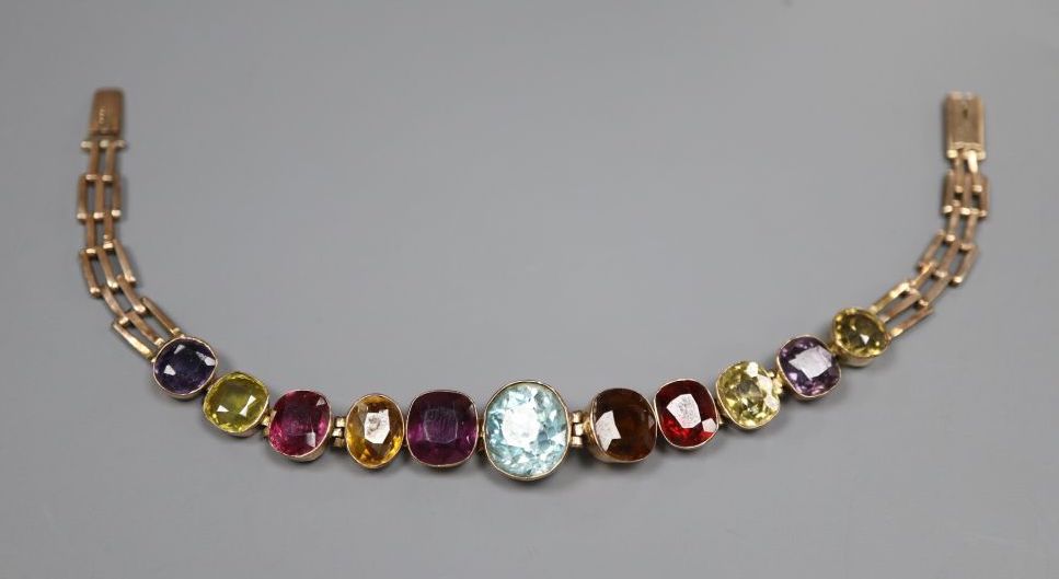 An early 20th century yellow metal and graduated multi gem stone set bracelet